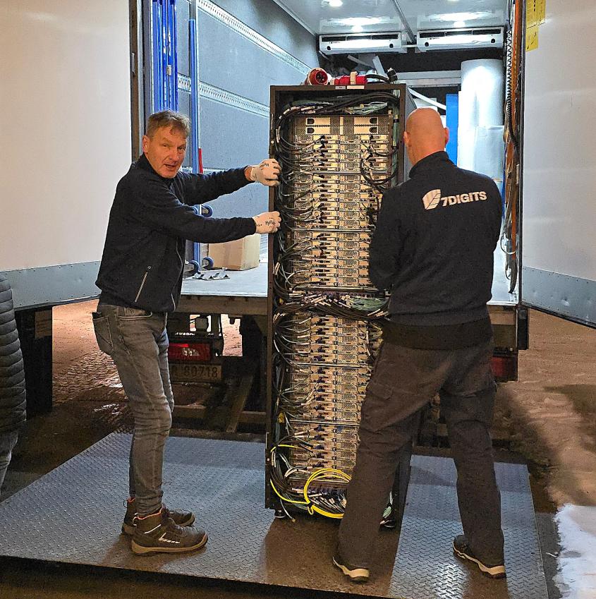 Two men hauling an HPC rack onto a truck.