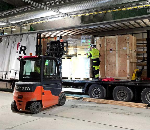 A truck working to unpack boxes from a trailer. 