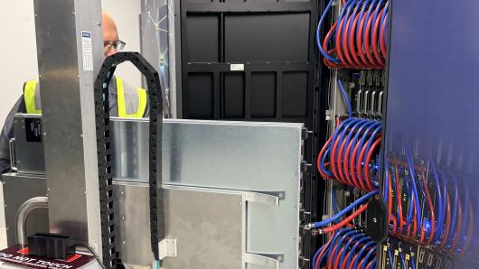 A technicial inserts a blade with GPUs inside a supercomputer 
