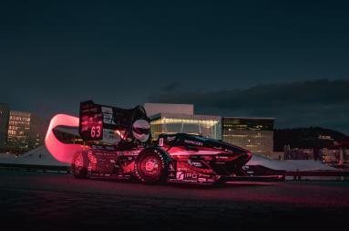 Formula racing car in a nighttime cityscape setting. 