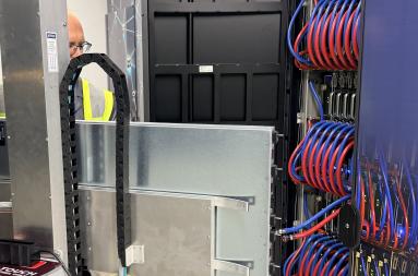 A technicial inserts a blade with GPUs inside a supercomputer 